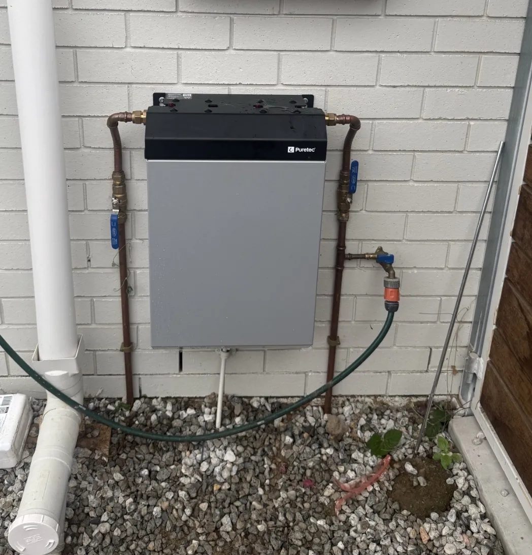 Whole house water filter installed on an exterior wall